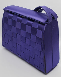 side view of purple handbag with woven details