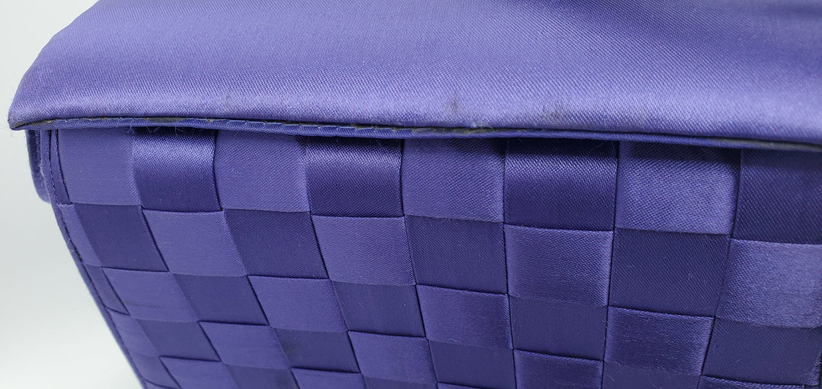close up top view of purple handbag with woven details
