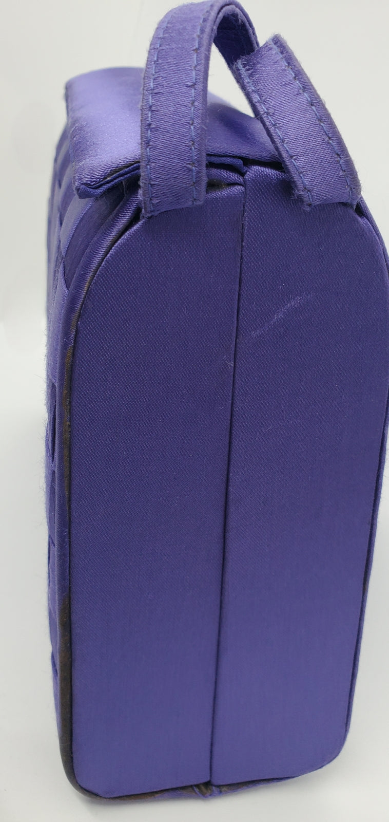 close up side view of purple handbag with woven details