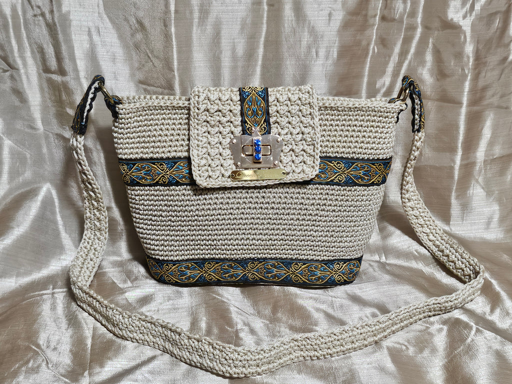 Front view of Cream coloured crochet handbag with Teal and Gold paisley trim