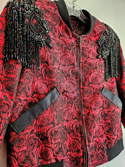 Close up front view of Red rose brocade bomber jacket with rhinestone appliqued shoulders with beaded fringe.