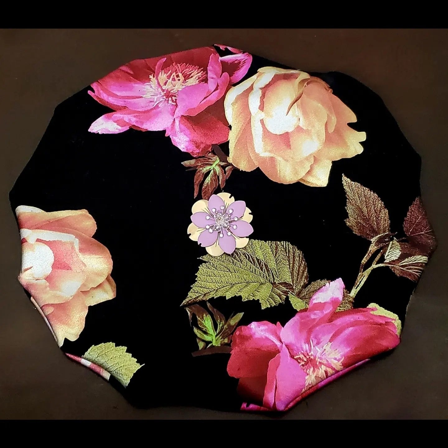 Floral beret with metallic flower accent on brown background