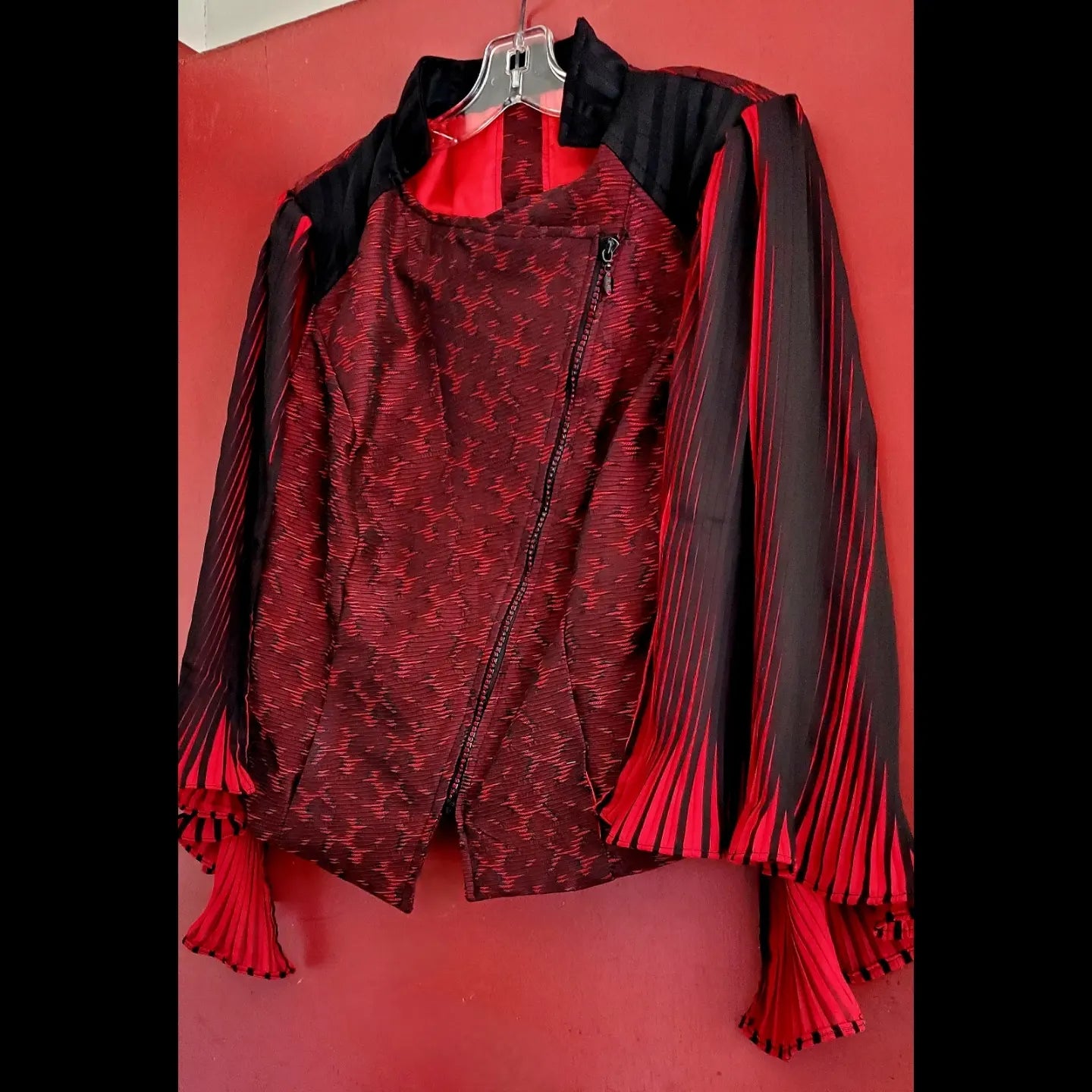 side view of red and black moto jacket with pleated cape sleeves and ruby rhinestone zipper