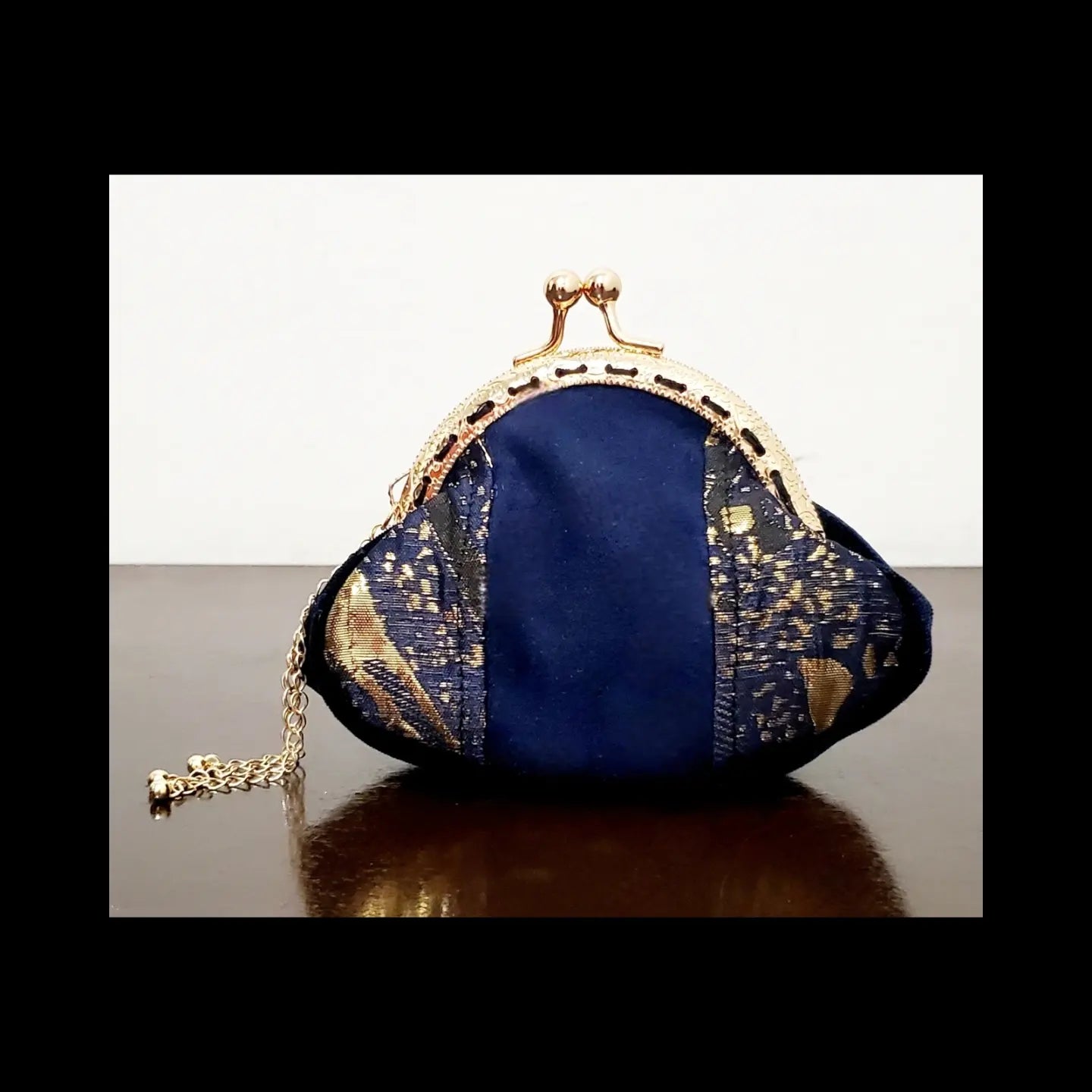 Front view of Blue and gold kiss clasp coin purse with gold tassel