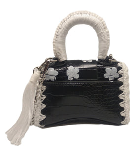 Back view of Black and white vegan leather handbag with crochet and distressed flower details