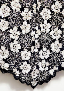 Close up view of scalloped hem of Vintage 80s Black and White Beaded Floral Top
