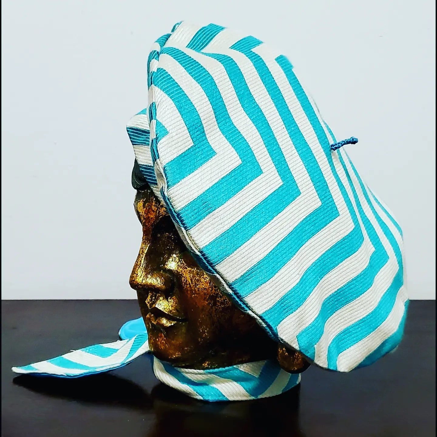 Side view. Turquoise and white chevron printed beret and matching scarf on mannequin head