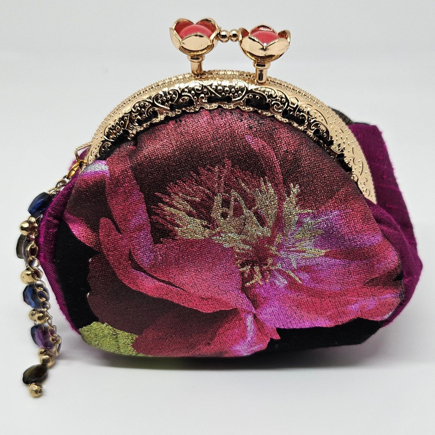 Front view of Metallic rose print kiss clasp coin purse with beaded tassel.