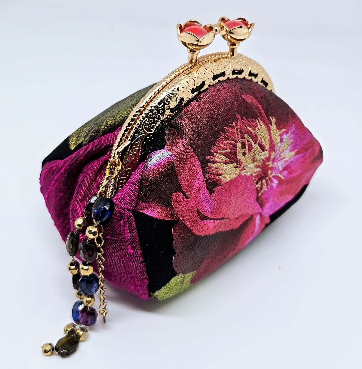 Side view of Metallic rose print kiss clasp coin purse with beaded tassel.