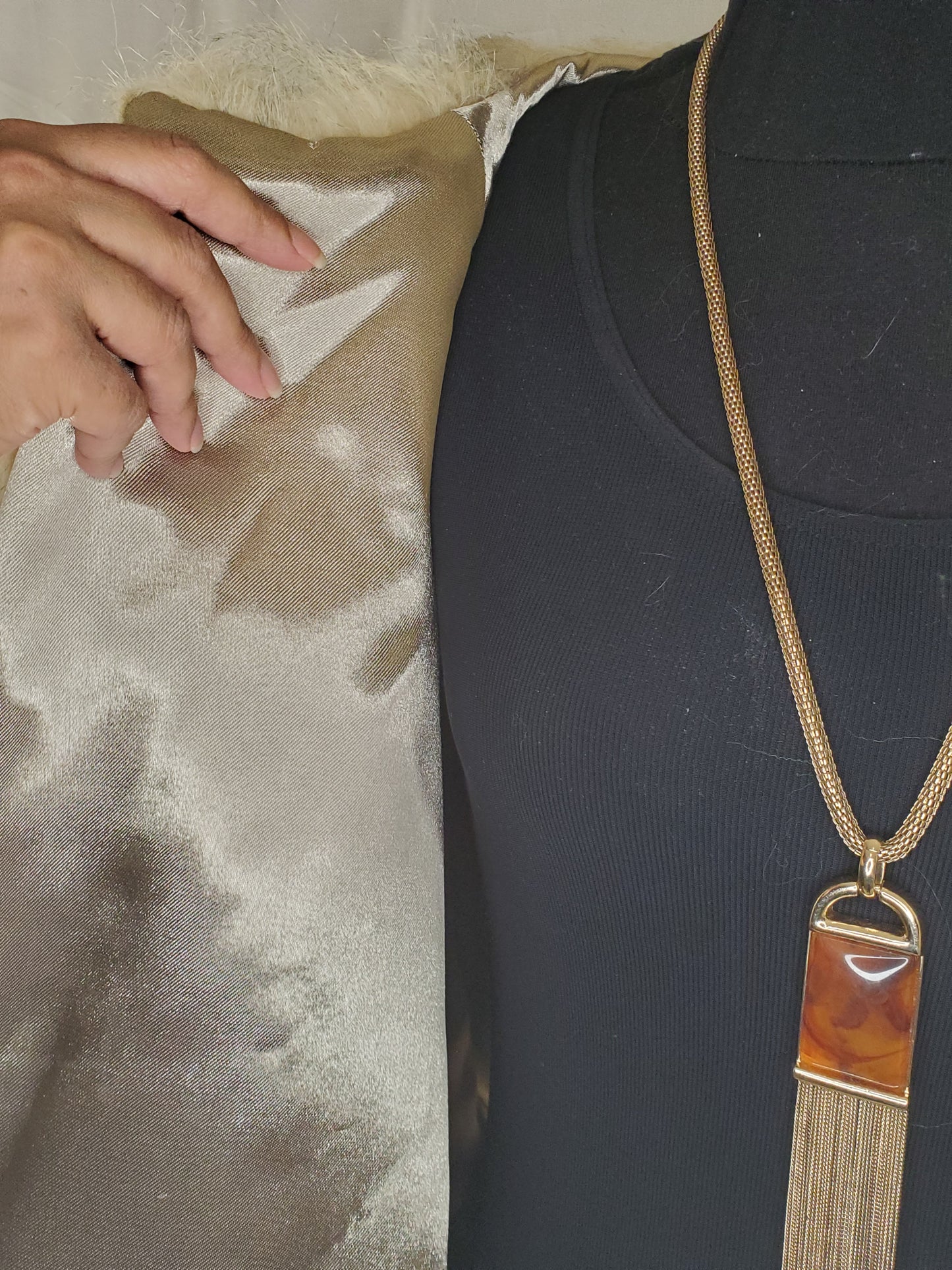 Cape lining with model hand and vintage necklace