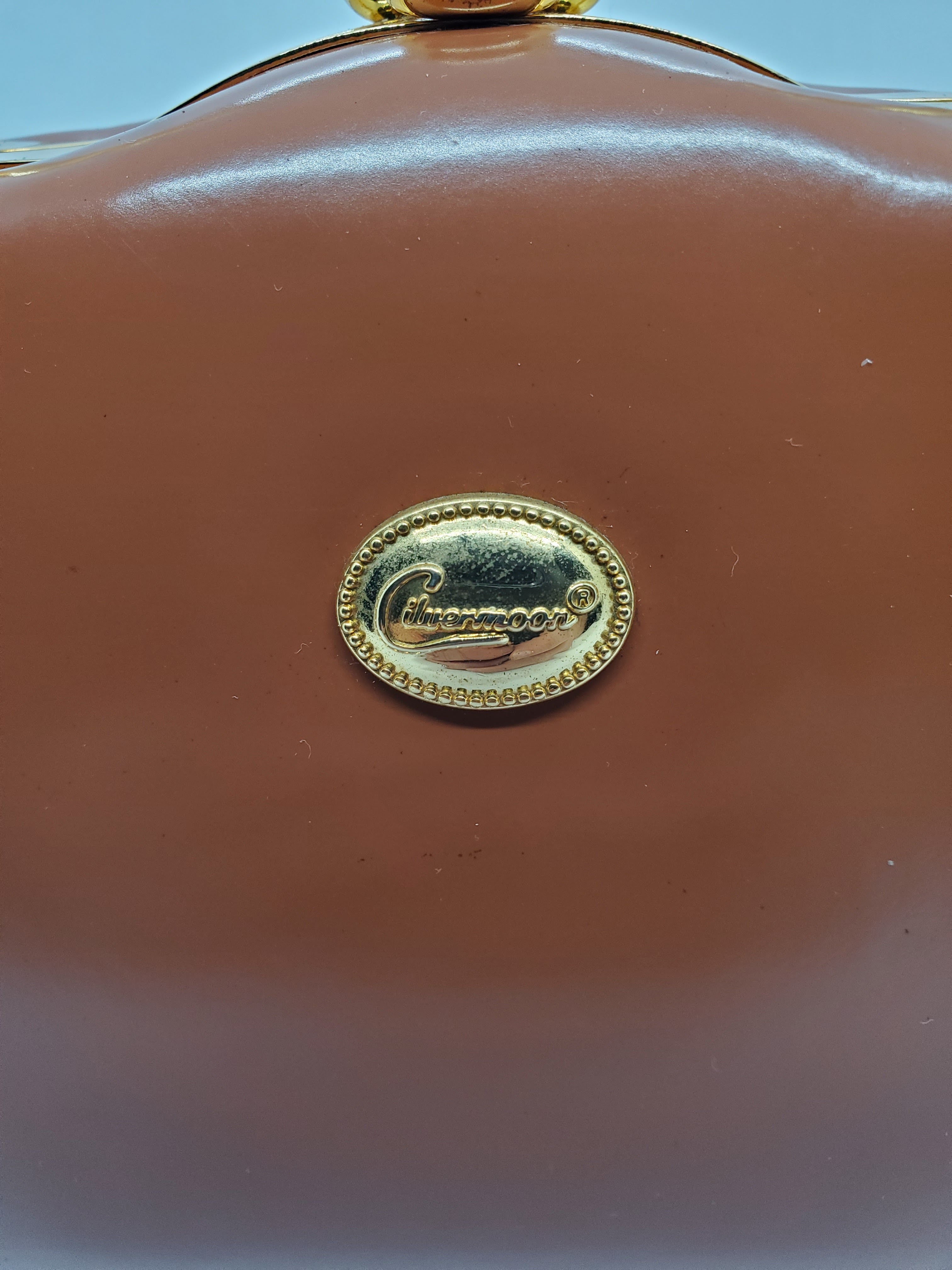 handbag tag view of tan and gold hard shell retro handbag