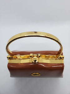 top clasp view of tan and gold hard shell retro handbag