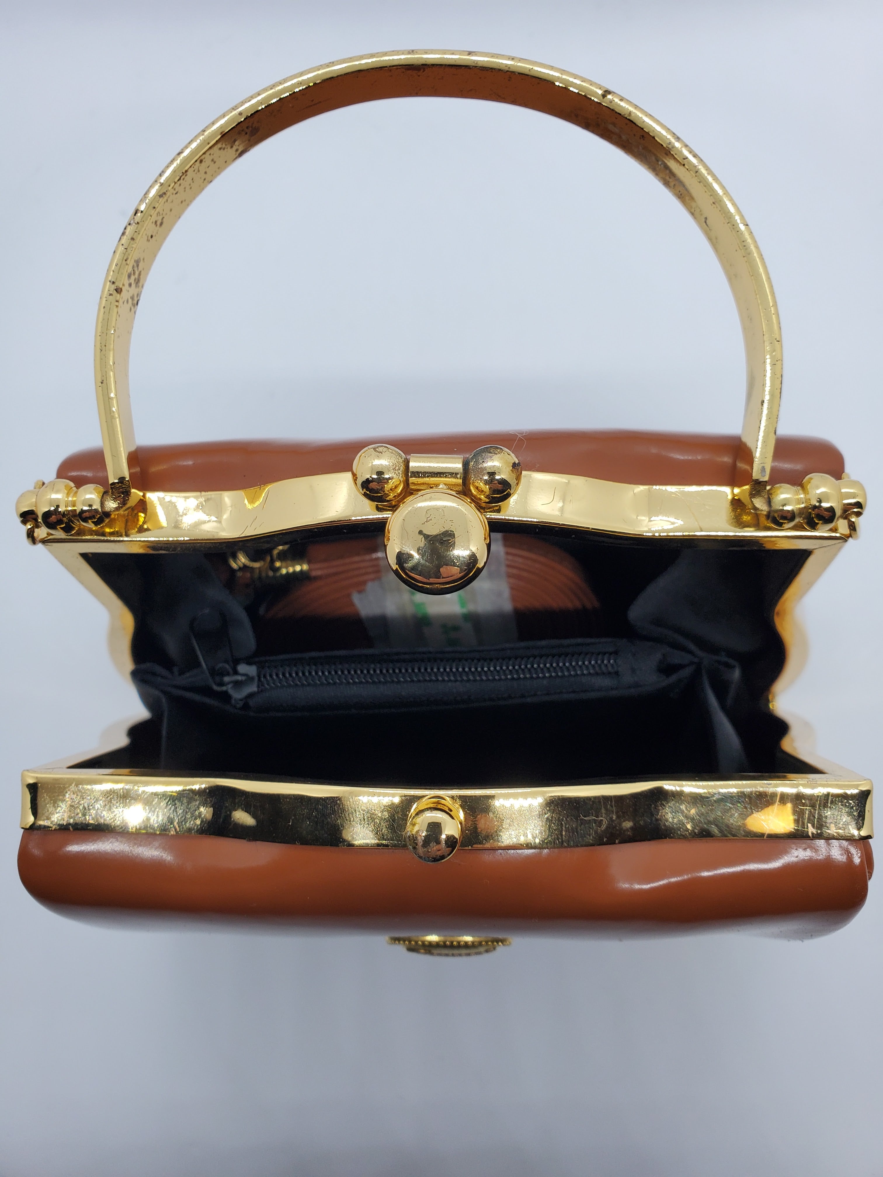 top inside view of tan and gold hard shell retro handbag