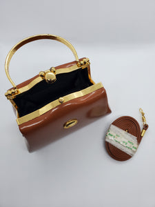 top view of tan and gold hard shell retro handbag with strap