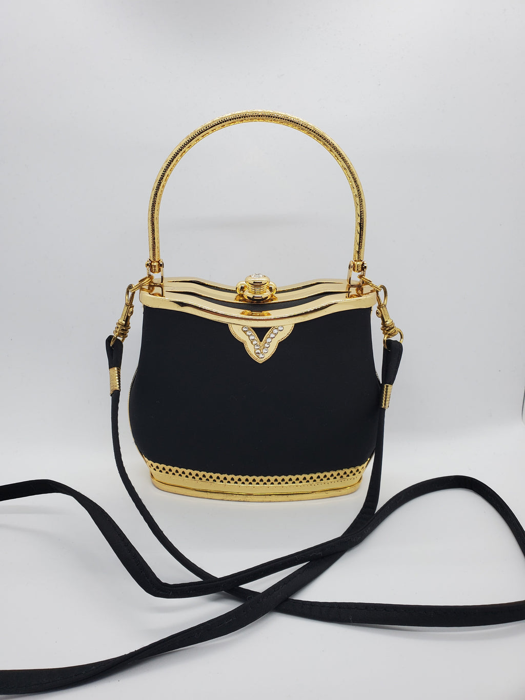 Front view of Smooth black handbag with ornate gold frame and handle with rhinestone accents and crossbody strap