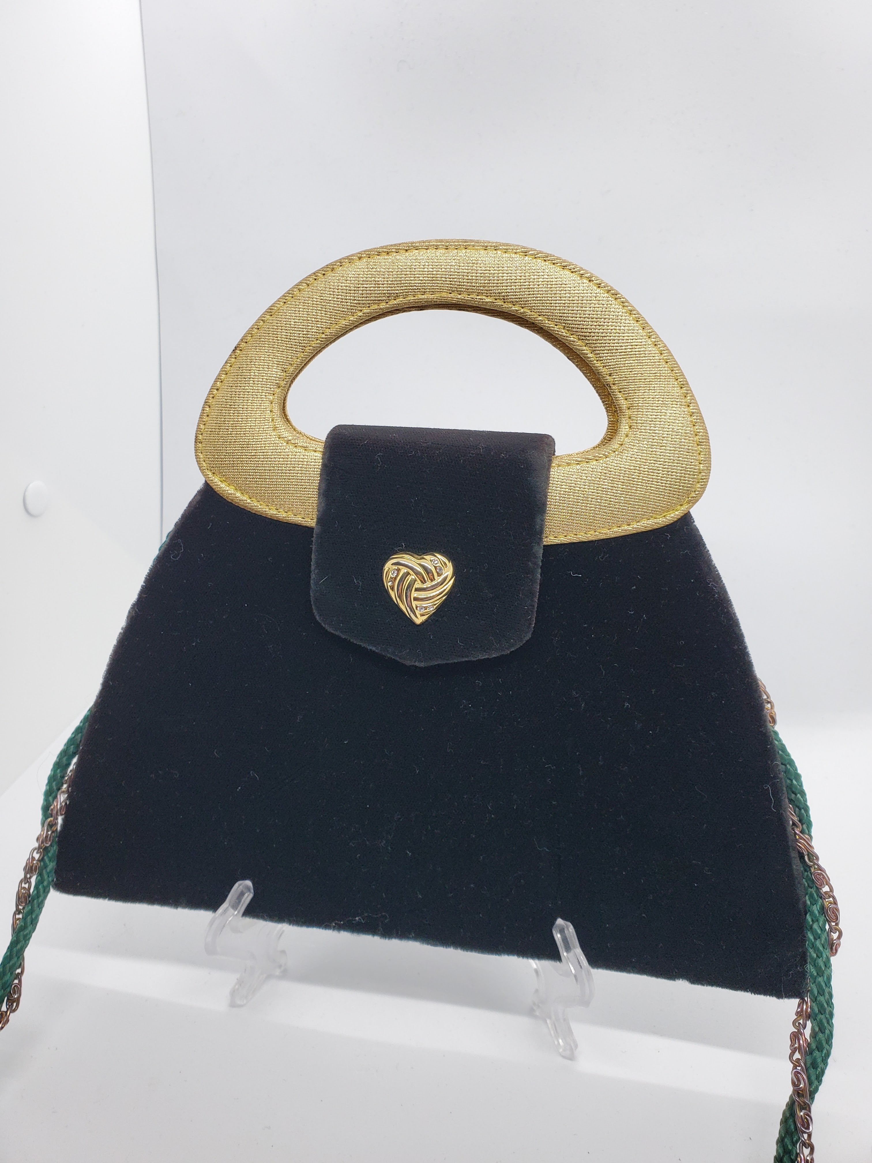 3/4 view of green and gold velvet handbag with heart detail