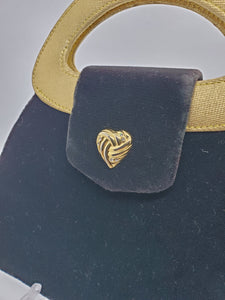 close up view of  heart detail on green and gold velvet handbag