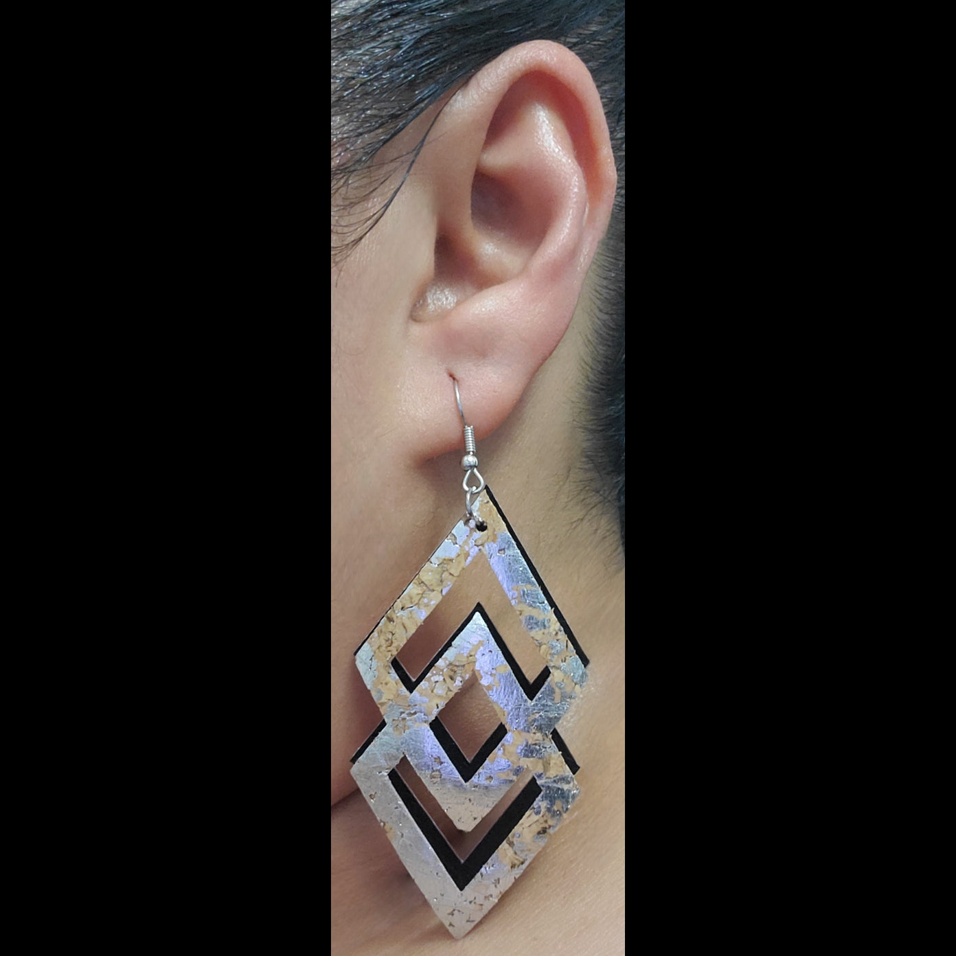 Cork with silver accent and black vinyl earrings on model