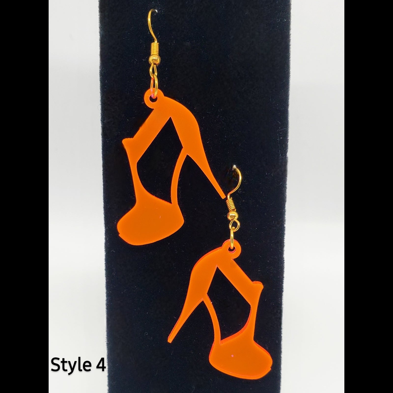 Orange strapped heel acrylic shoe earrings on stand