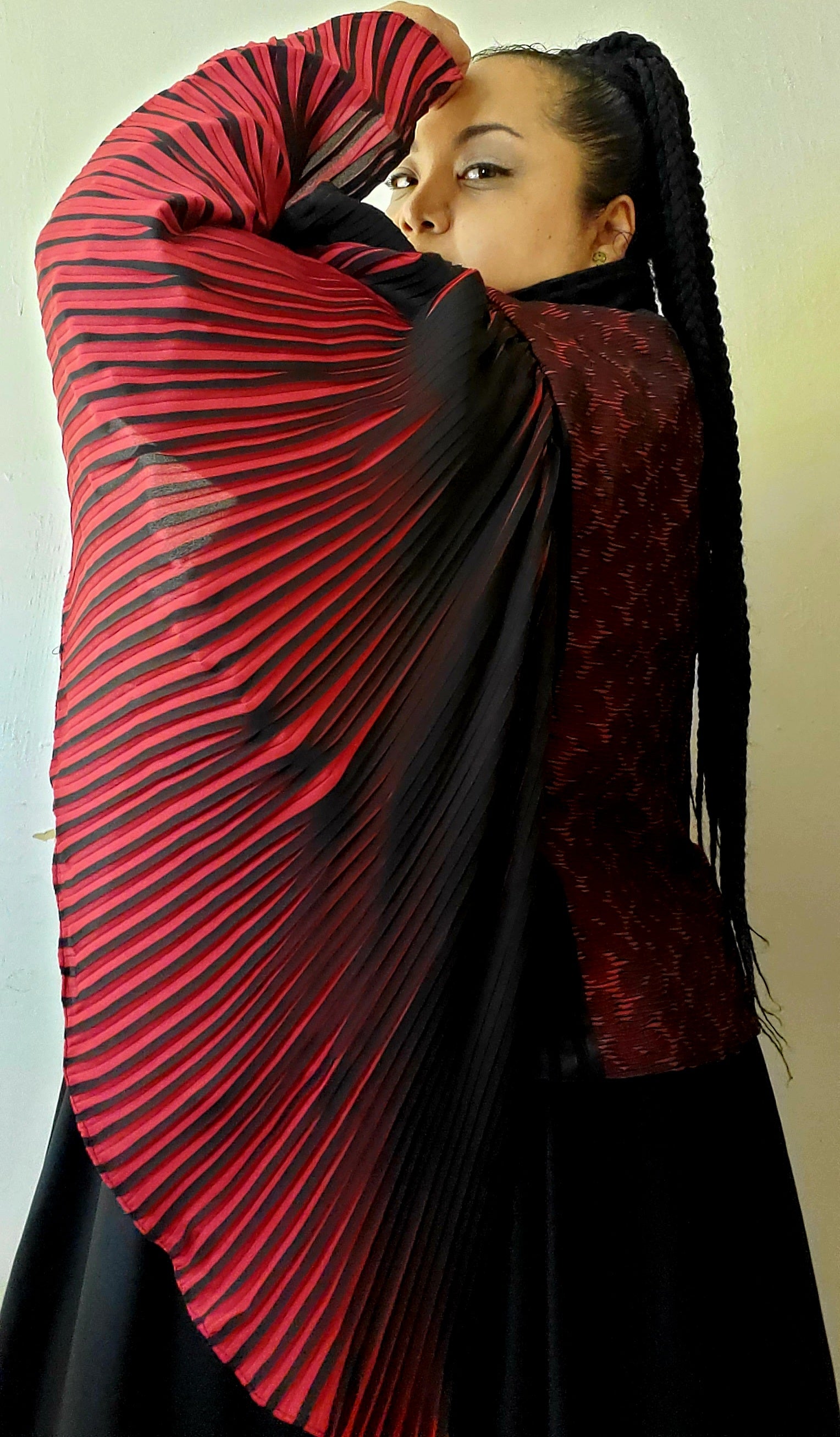Model wearing red and black moto jacket with pleated cape sleeves