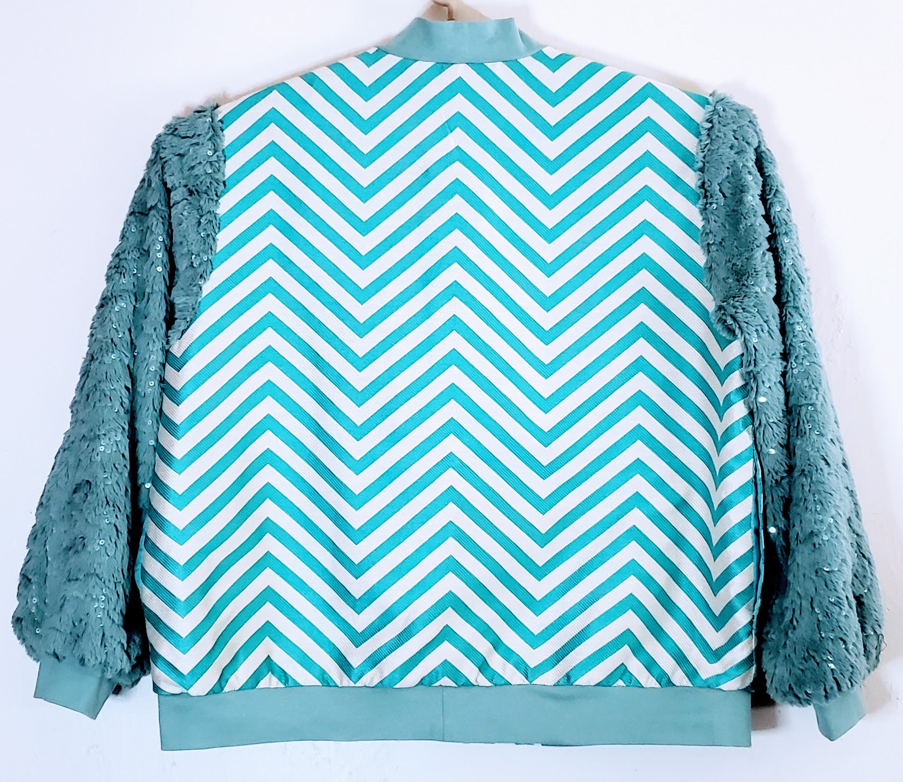Back view of Turquoise chevron print bomber jacket with sequined fur sleeves
