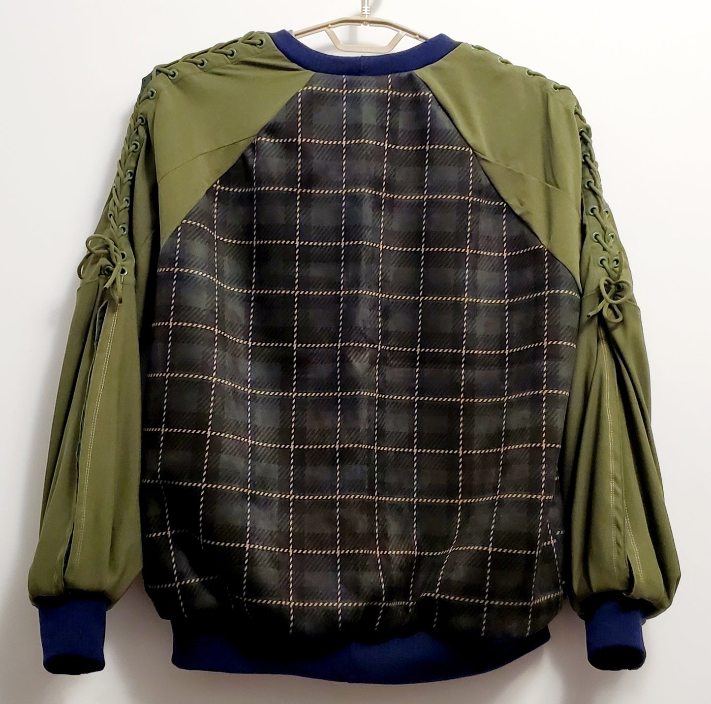 back view of Forest green plaid bomber jacket with split sleeves and laced shoulder details.