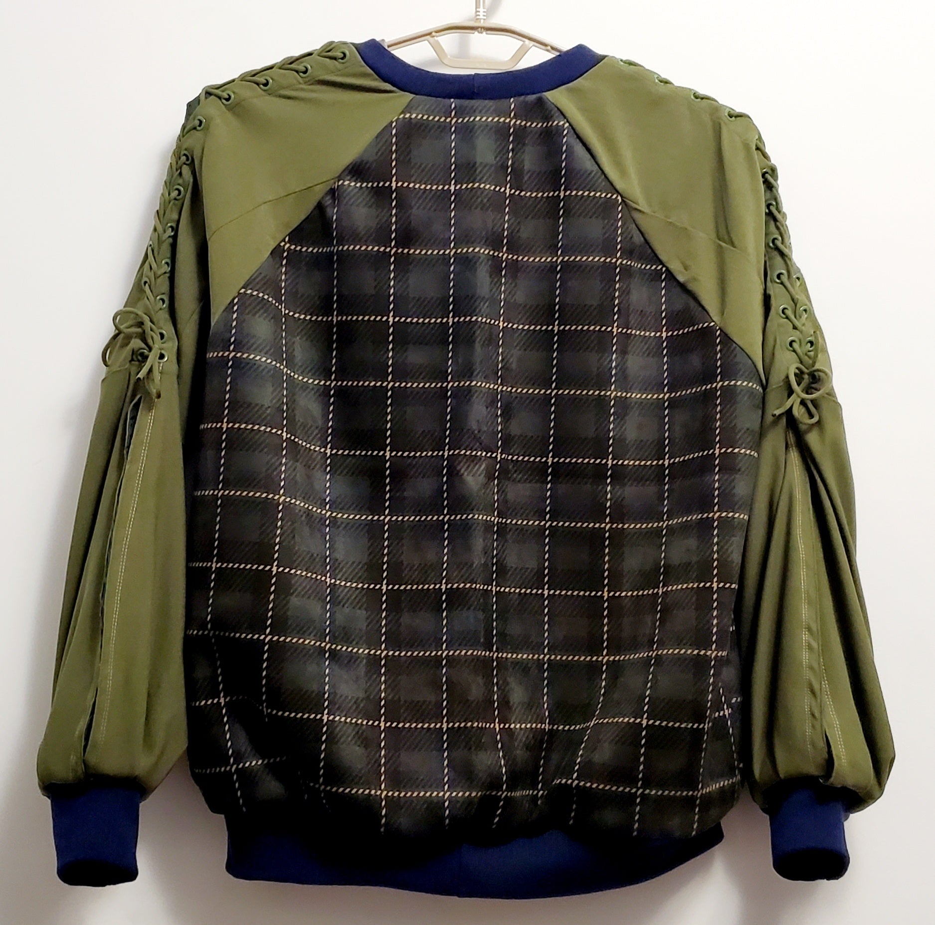 back view of Forest green plaid bomber jacket with split sleeves and laced shoulder details.