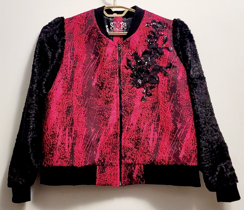 Front view of Fuchsia and black bomber jacket with faux fur sleeves and sequin applique details