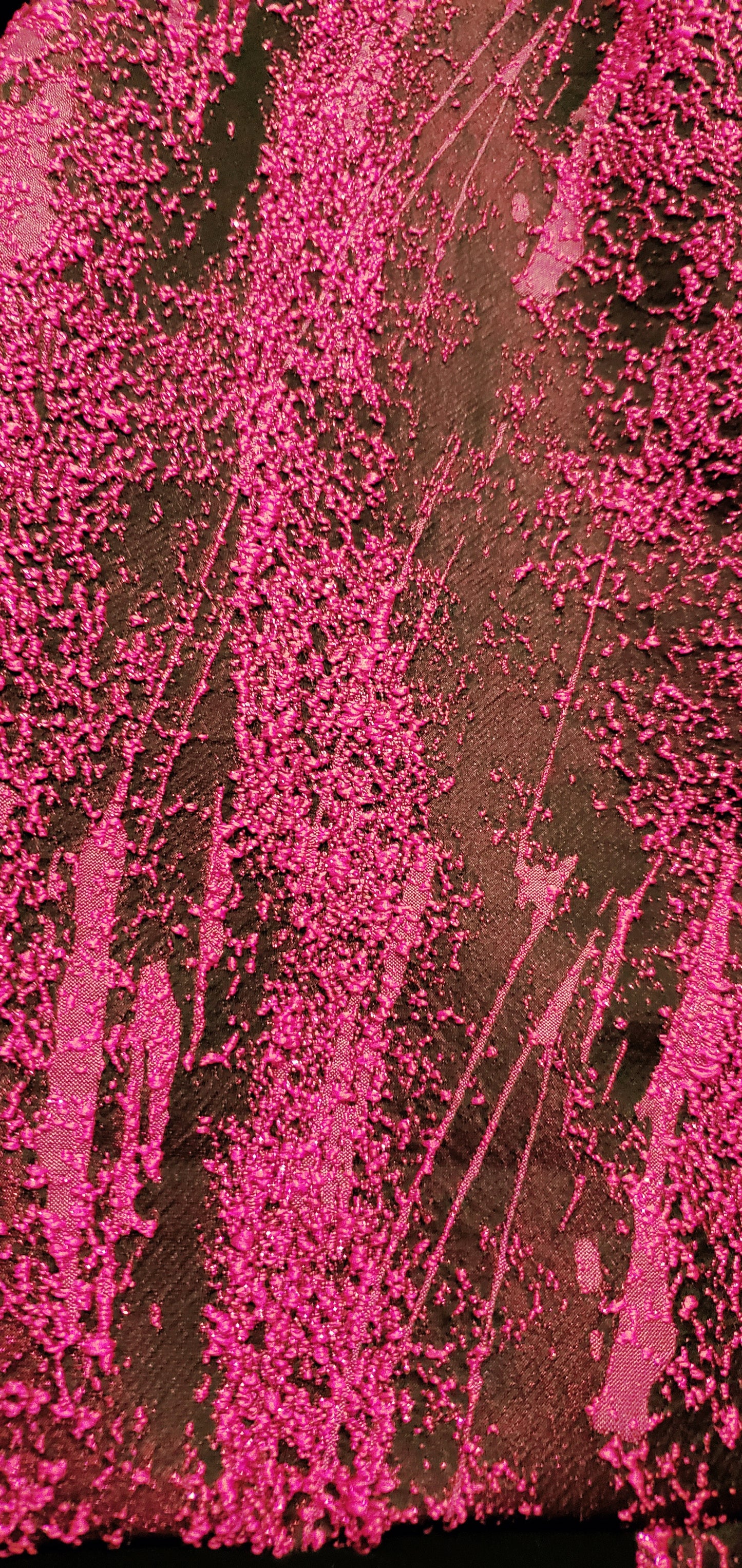 close up view of the fabric of Fuchsia and black bomber jacket with faux fur sleeves and sequin applique details