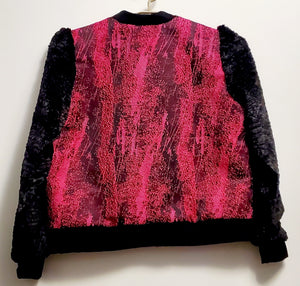 Back view of Fuchsia and black bomber jacket with faux fur sleeves and sequin applique details