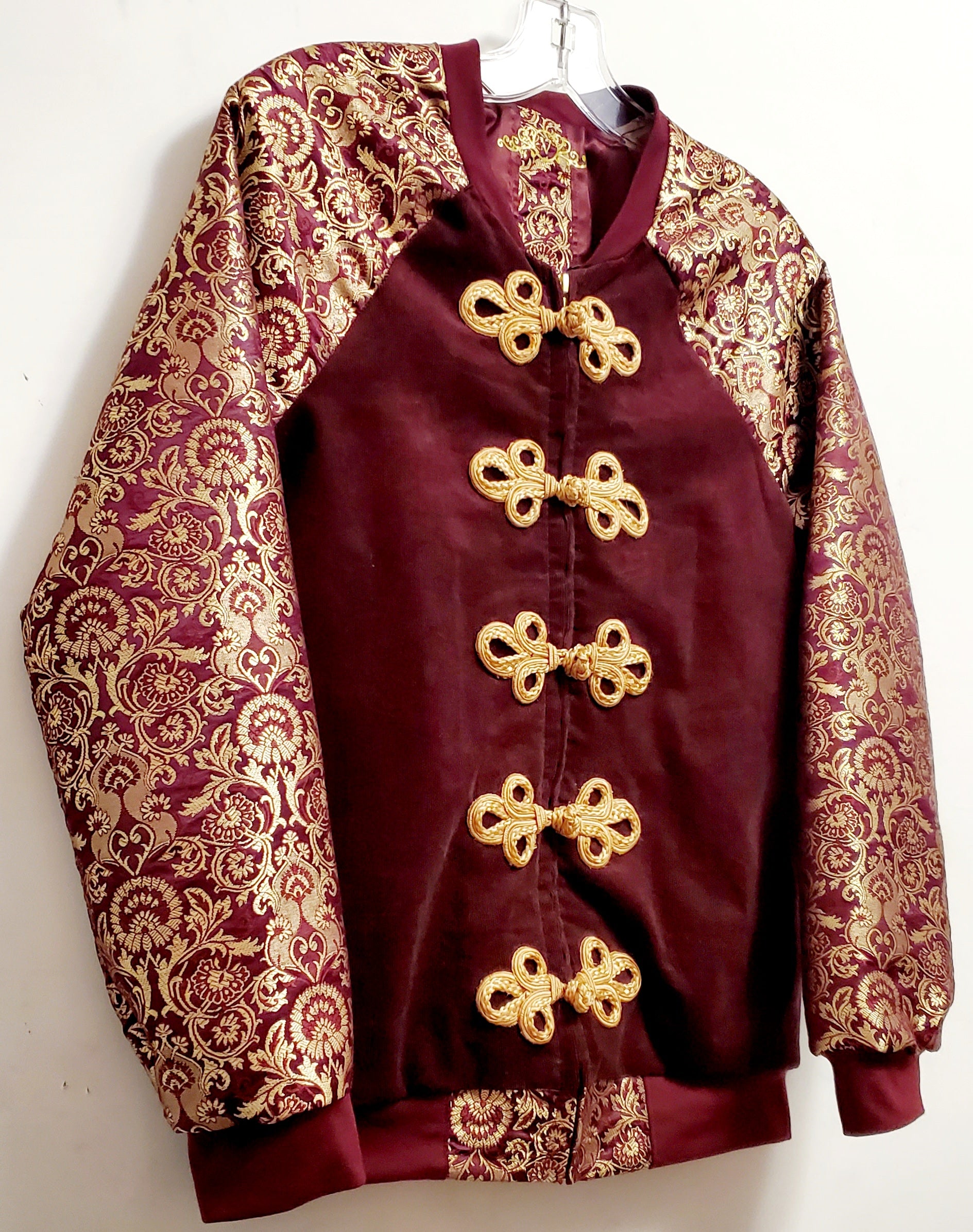 side front view of Burgundy corduroy bomber jacket with metallic gold sleeve and knot closures