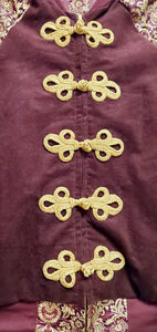 close up front view of Burgundy corduroy bomber jacket with metallic gold sleeve and knot closures
