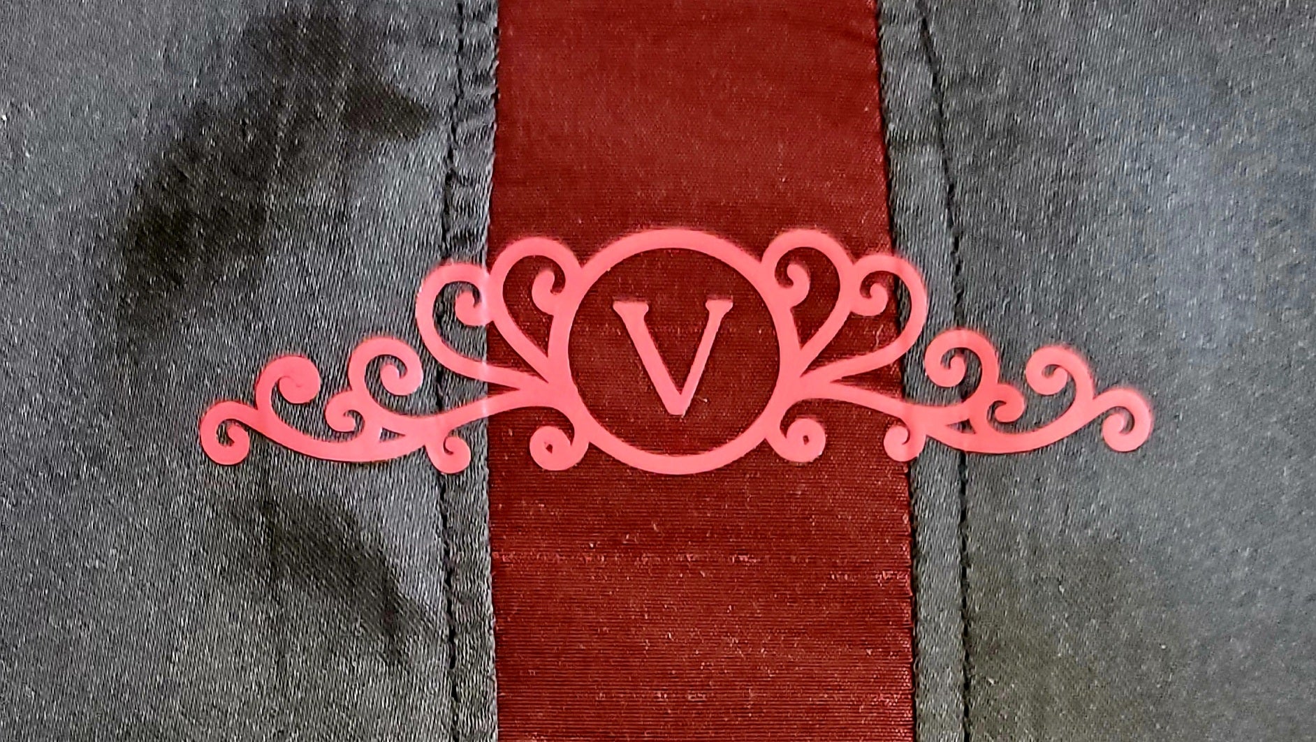 Label of red taffeta and black velveteen colour-blocked bomber jacket with white cord piping