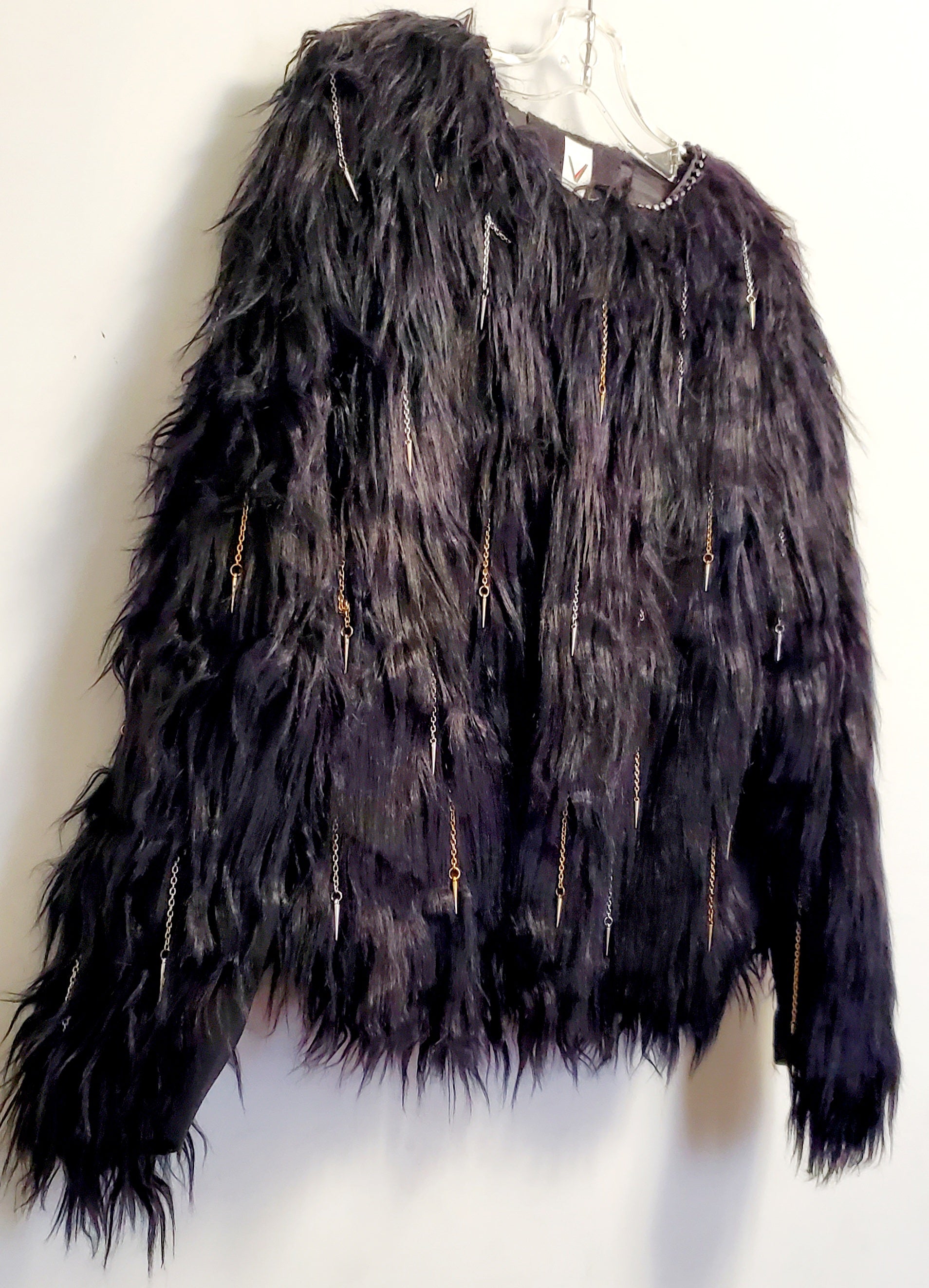 close up front view of faux fur black coat with chain and spike details 