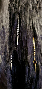 close up view of faux fur of black coat with chain and spike details 