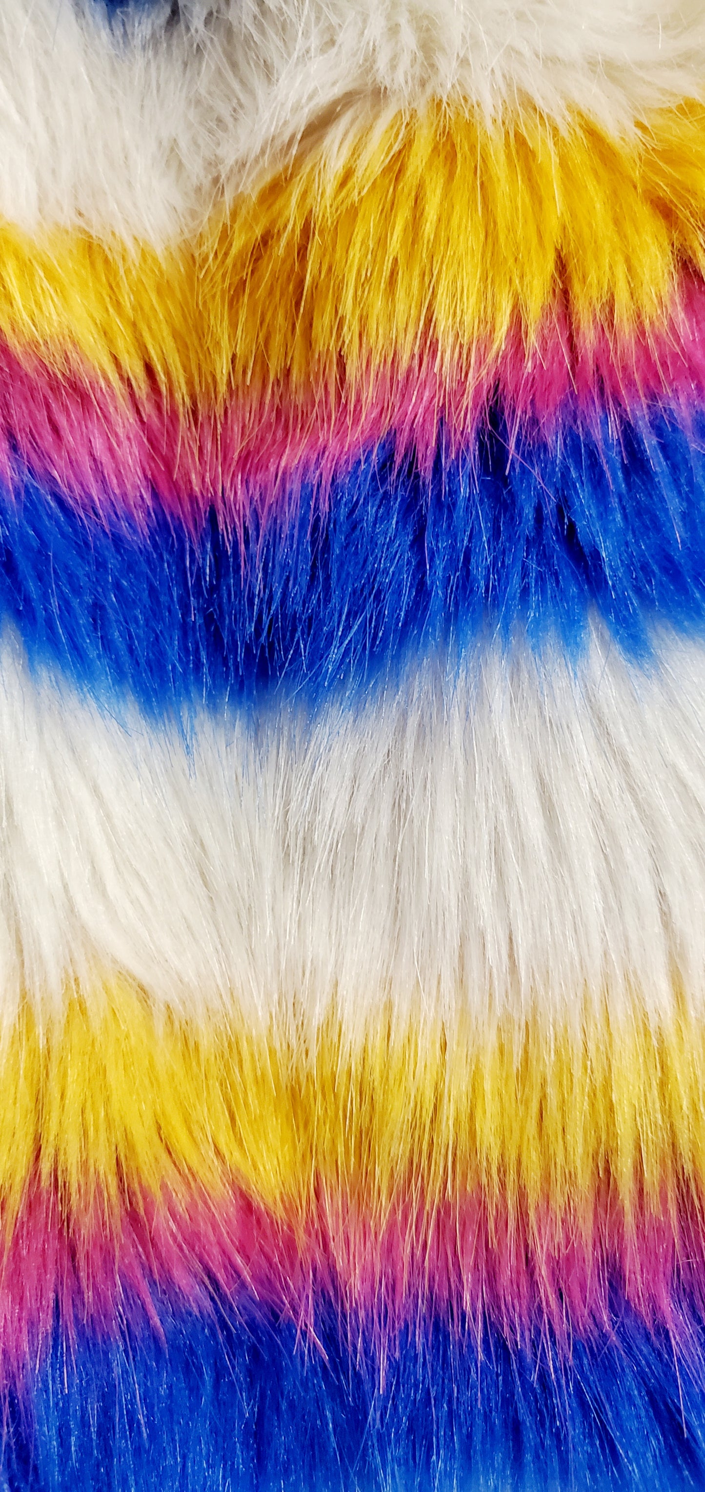 close up view of faux fur of white rainbow striped faux fur coat with chain details