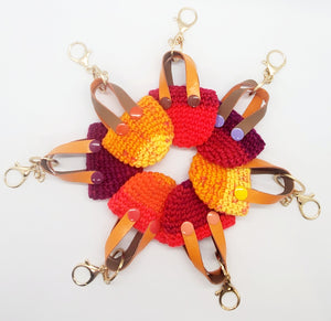 group view (circle) of orange with purple Crochet mini tote keychains with vinyl handles