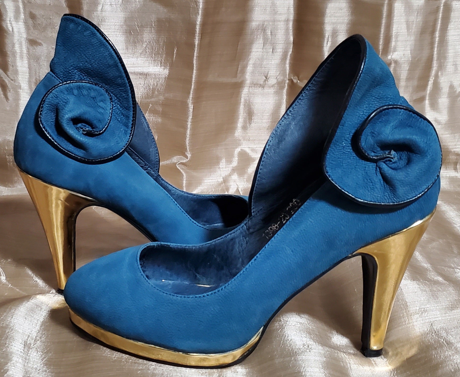 Side view of Suann Villa blue and gold leather pumps with ruffle details