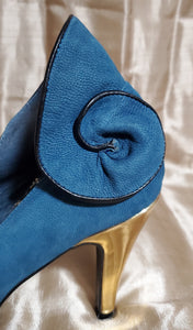 Heel view of Suann Villa blue and gold leather pumps with ruffle details