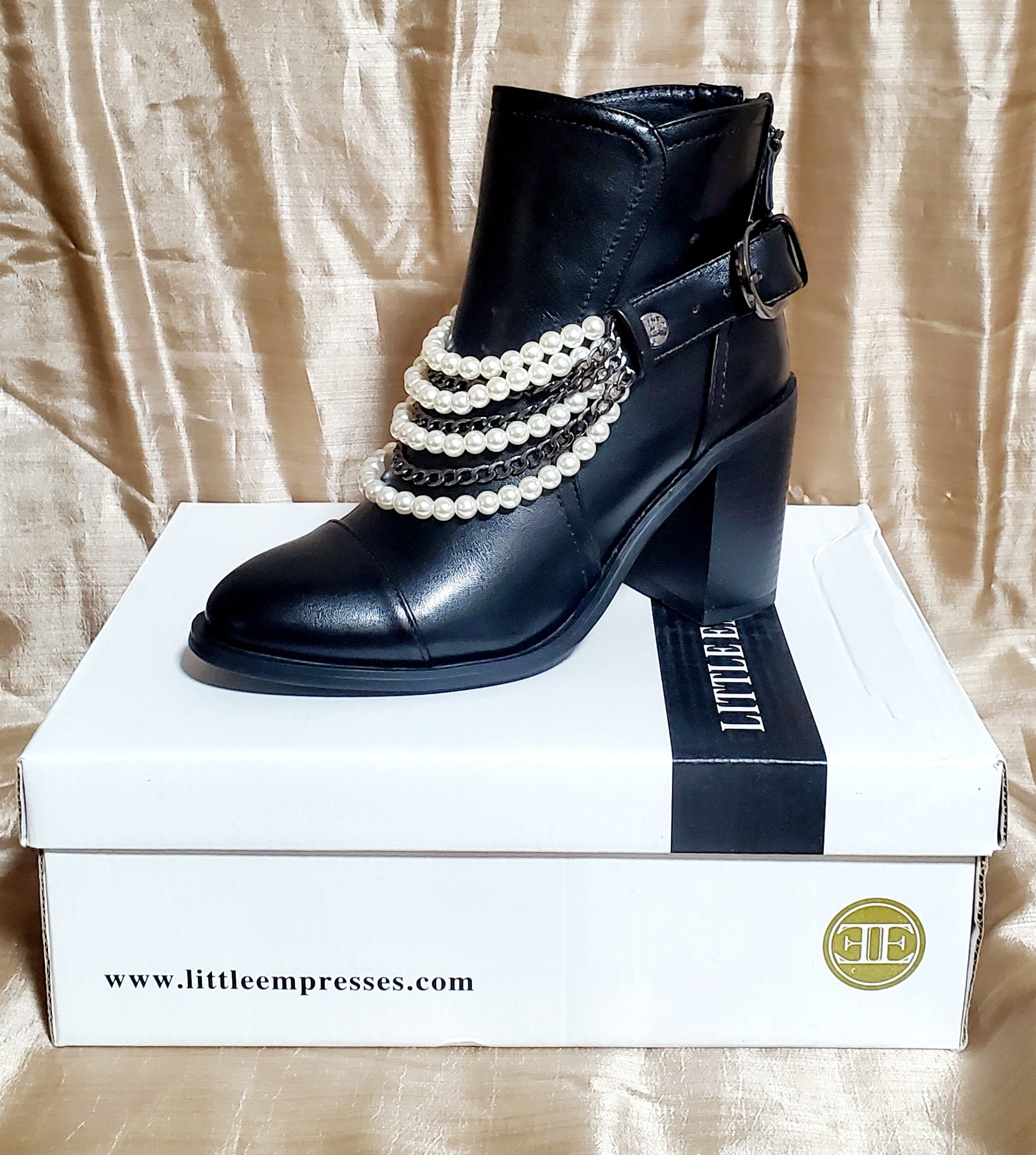 Left side view of Black booties with pearl and chain details