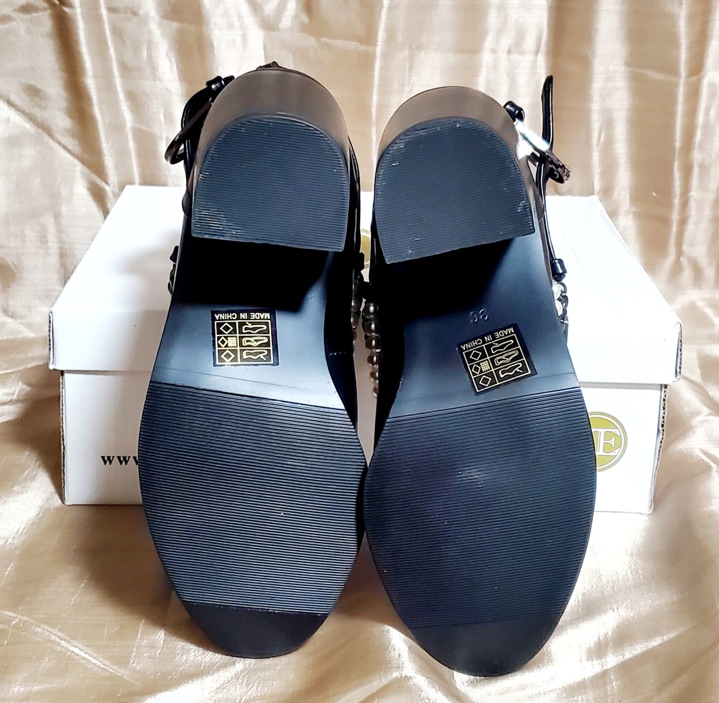 Under sole view of Black booties with pearl and chain details