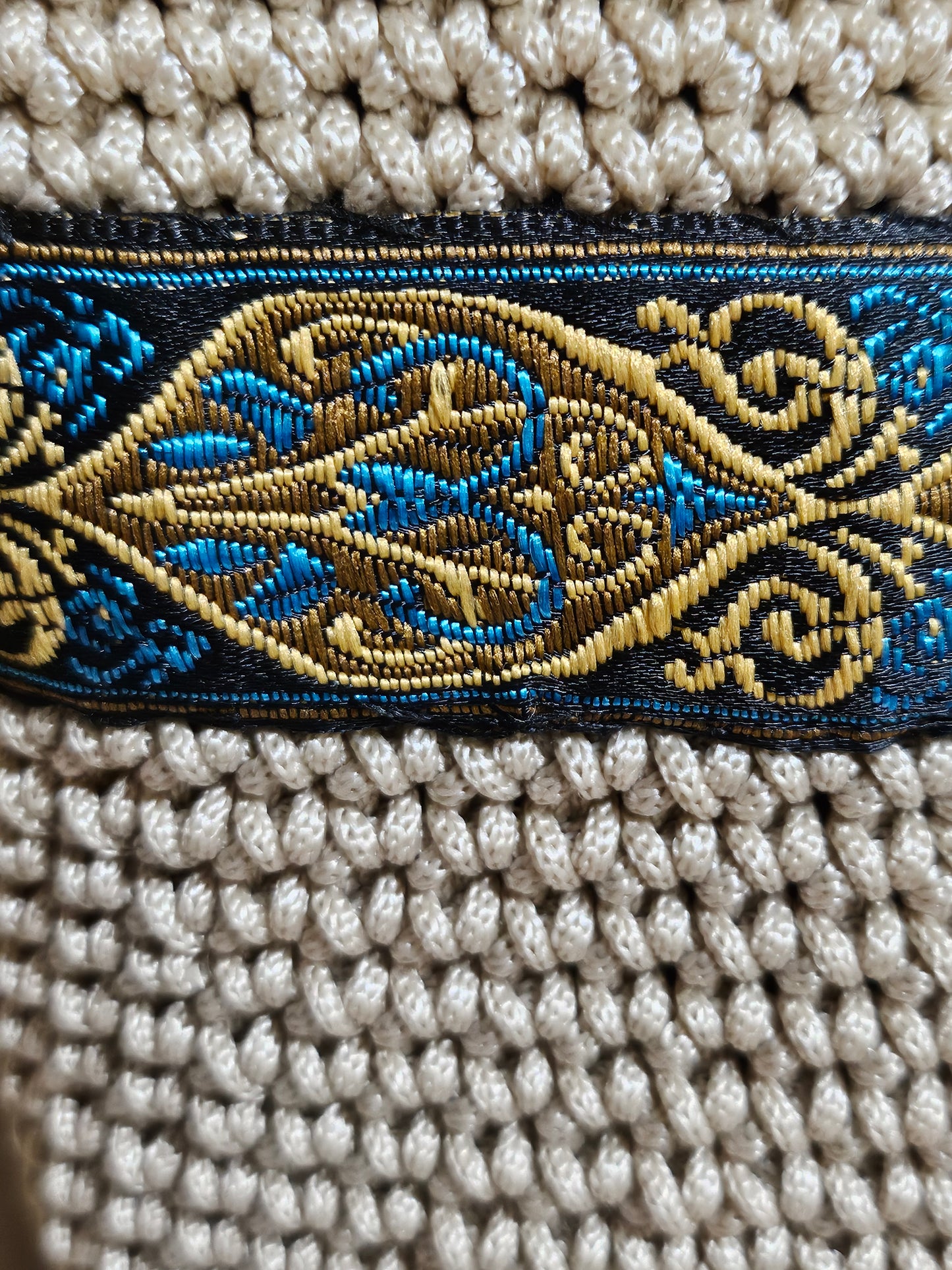 close up view of trim Cream coloured crochet handbag with Teal and Gold paisley trim