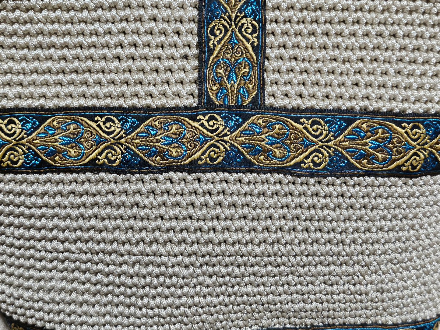 Close up back view of Cream coloured crochet handbag with Teal and Gold paisley trim