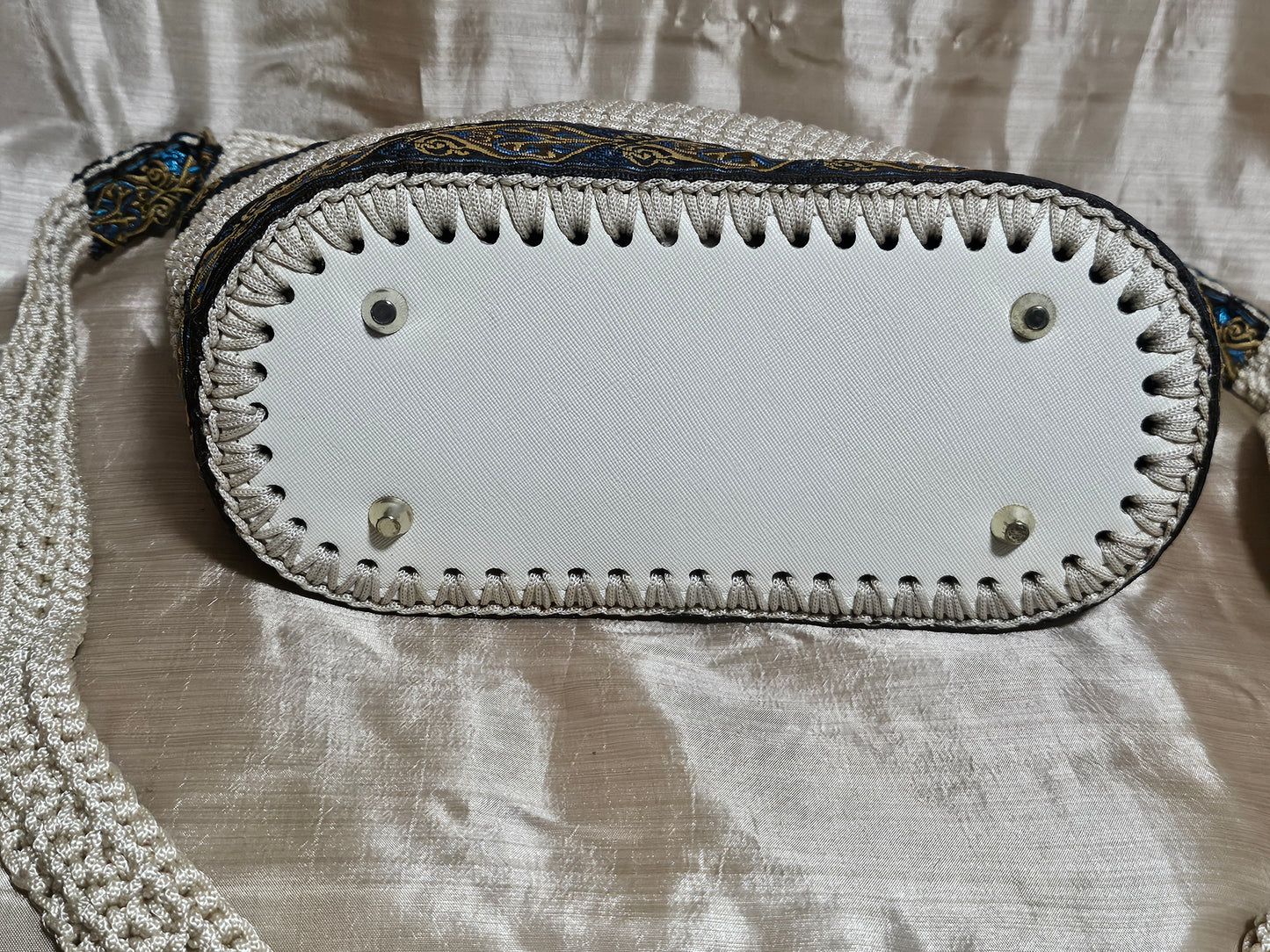 Bottom view of Cream coloured crochet handbag with Teal and Gold paisley trim