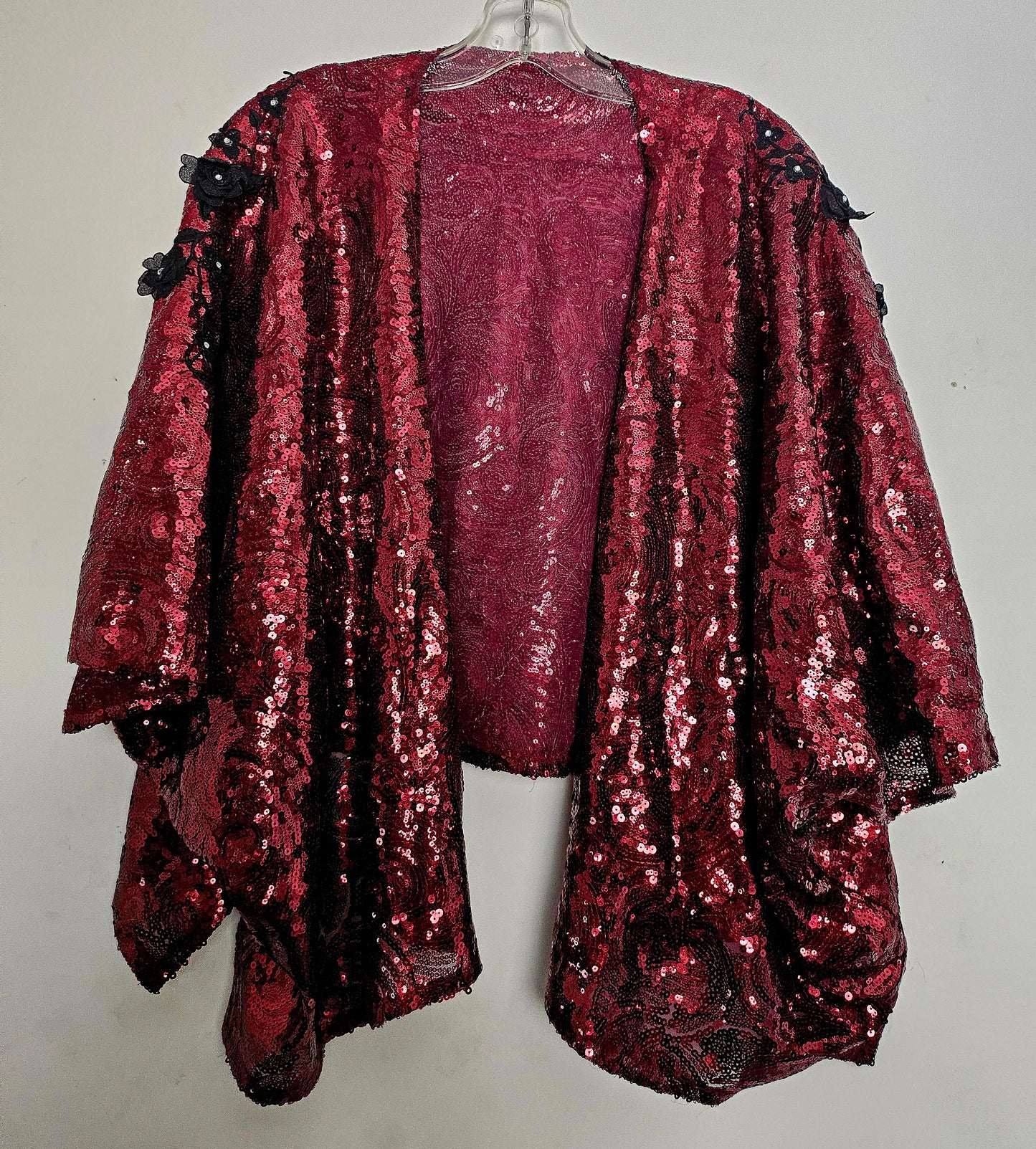 front view of Burgundy sequin kimono jacket with black embroidered shoulders on hanger