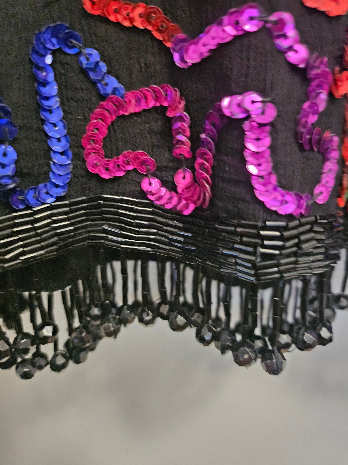 close up view of fringe hem on Rainbow sequined jacket dress with fringe details
