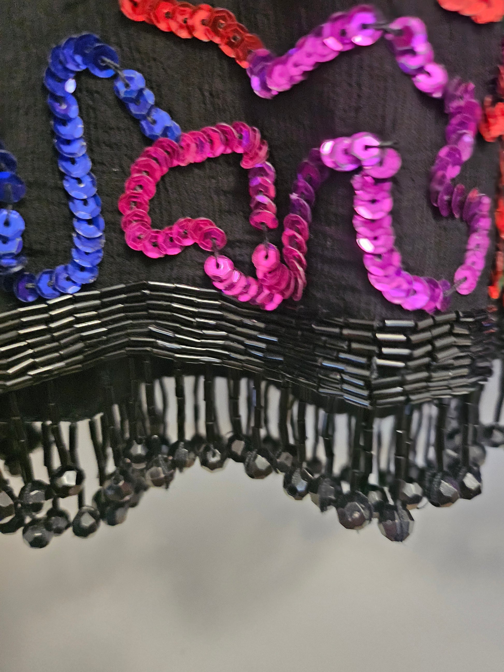 close up view of fringe hem on Rainbow sequined jacket dress with fringe details