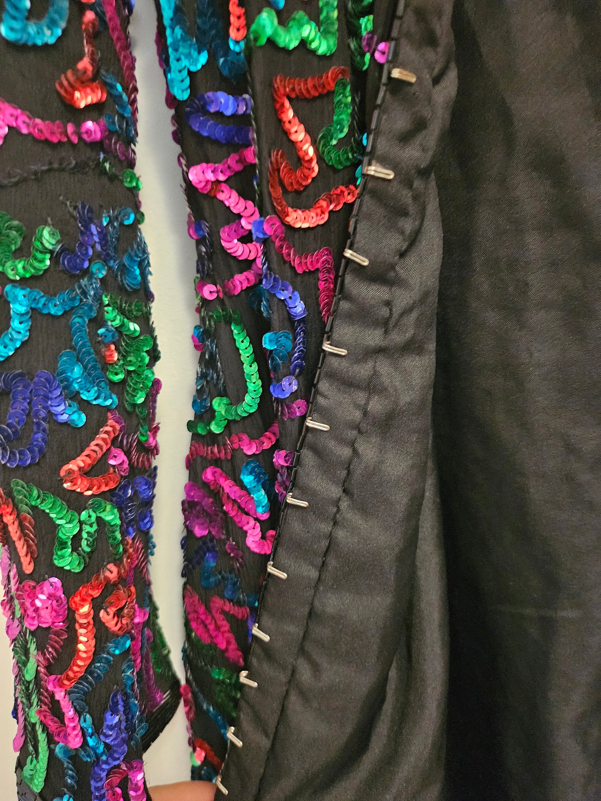Close up of hook and eye closures on Rainbow sequined jacket dress with fringe details