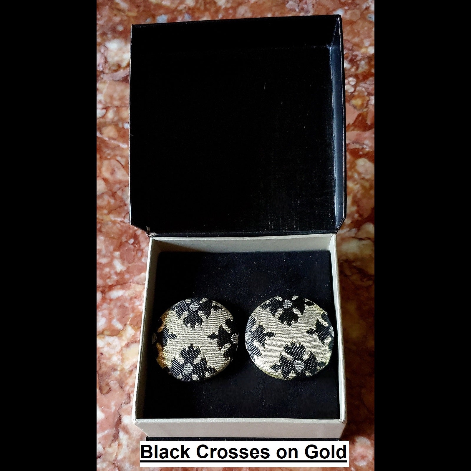 black crosses on gold print button earrings in jewelry box