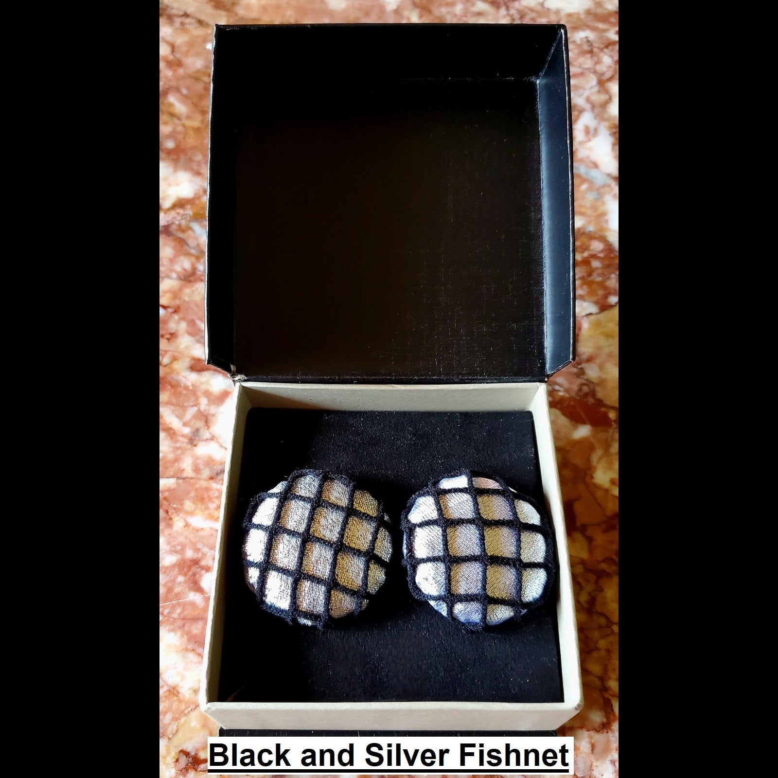 Black and silver fishnet print button earrings in jewelry box